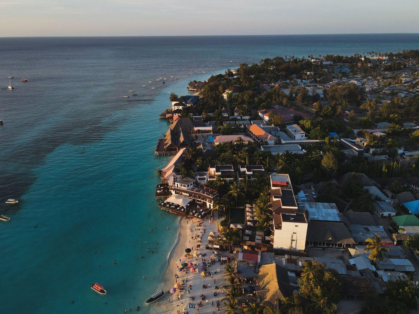 A resort shoreline curving along pale sand and turquoise shallows