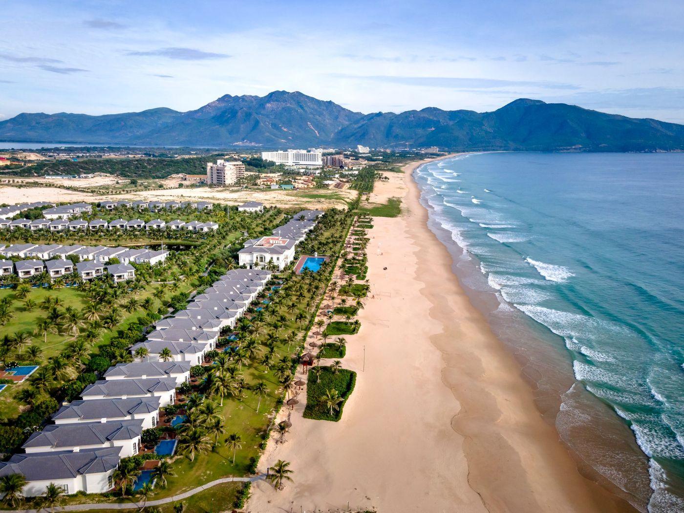 Beachfront resort buildings along a sandy shore with waves breaking offshore